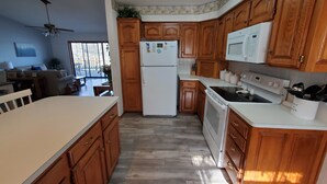 A kitchen with wooden cabinets, a refrigerator, a microwave, an oven, and a dishwasher. - BERGS NEST-Lakefront Home-Incredible Shoreline Close to House!  (Garfield)