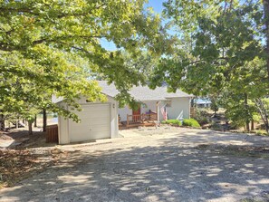 A residential property with a garage, a covered porch, and a flag.