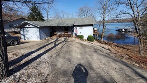 A house with a garage, a driveway, and a dock extending into a lake. - BERGS NEST-Lakefront Home-Incredible Shoreline Close to House!  (Garfield)