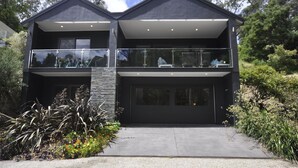 A modern two-story house with a garage, large windows, and a balcony. - The Boulevard House Lorne (Lorne)