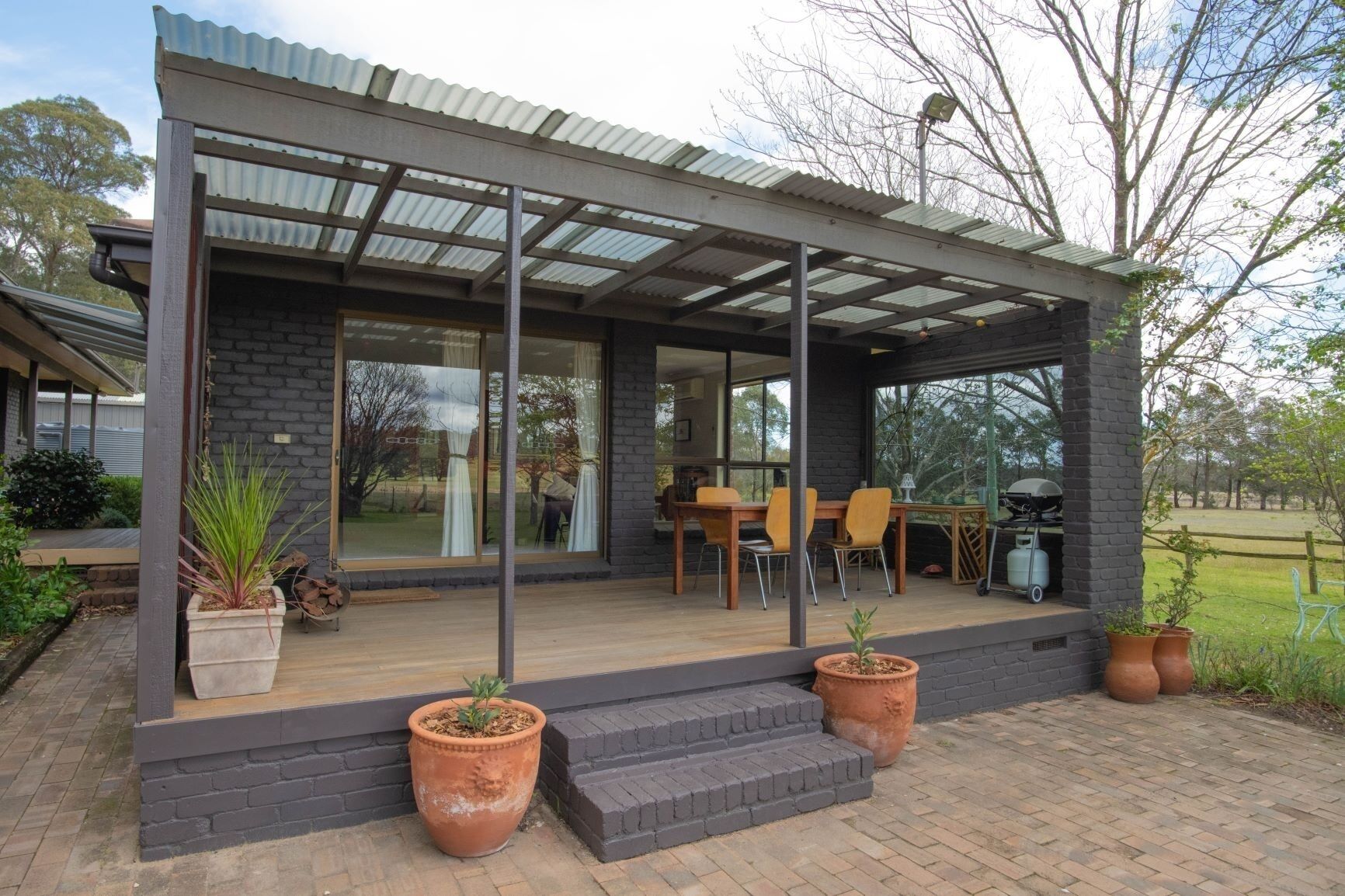 The front of the cottage with deck, table/chairs and Weber BBQ