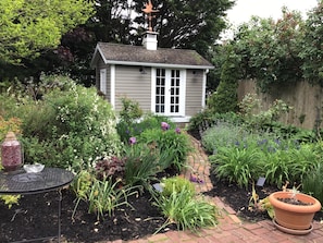 A house with a garden, a metal table, and a potted plant.