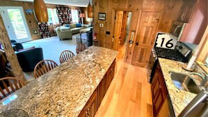 Eine Küche mit Granit-Arbeitsplatten, Holzschränken und einer Spüle aus Edelstahl.