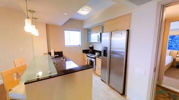 A compact kitchen with a central island, a built-in oven, and a refrigerator.