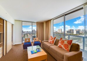 Enjoy a panoramic city view from the large window in this stylish room, featuring a comfortable sofa and two armchairs.