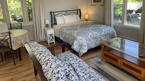 Una camera da letto con un letto, un comodino, una lampada e vista sull'esterno.