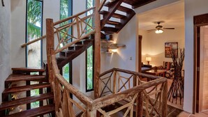 A wooden staircase with a rustic design, leading to a room with a ceiling fan and a view of palm trees through large windows. - Villa Umakiha, Secluded Beach Villa with Private Pool + Jacuzzi! (Playa Del Carmen)