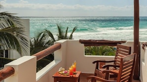 A balcony with a wooden table and chairs, overlooking the ocean. - Villa Umakiha, Secluded Beach Villa with Private Pool + Jacuzzi! (Playa Del Carmen)