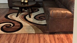 Una sala de estar con un sofá modular, una mesa de centro y un tapete estampado.