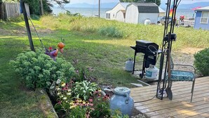 Un jardín con diversas plantas y una zona de barbacoa.