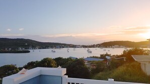 Blick auf die Küste mit einem Yachthafen, Booten und Gebäuden im Hintergrund.