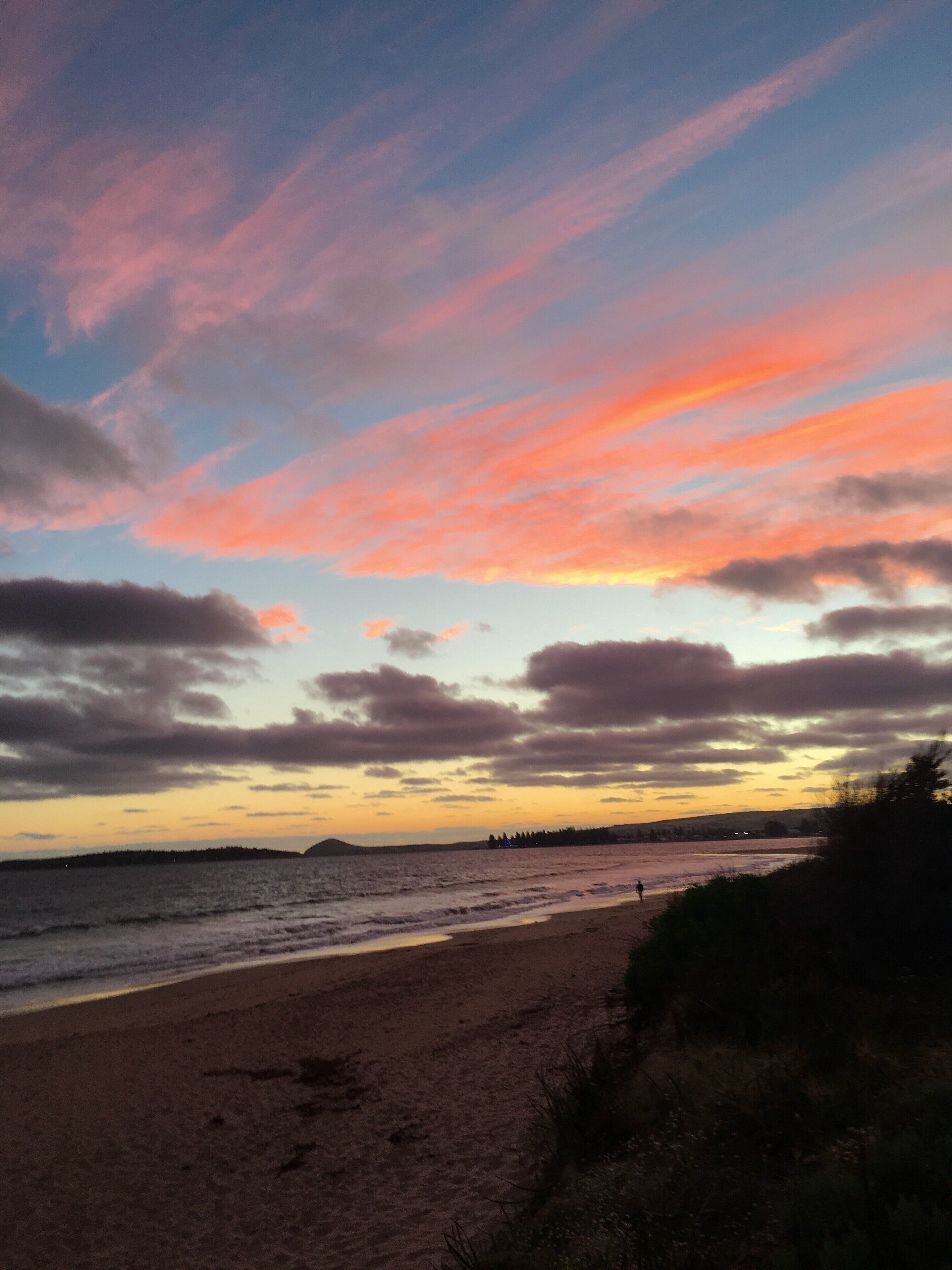 A beach with a sunset sky.