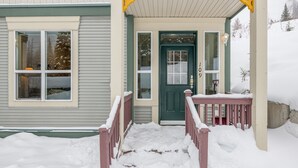 A house with a green door, a porch with a red railing, and a number '109' on the door. -  Location, Location, Location! Large Corner Ground Floor Newly Renovated Condo (Silver Star Mountain)