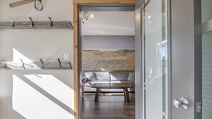 A modern interior with a wooden floor, a sofa, and a painting of a landscape. -  Location, Location, Location! Large Corner Ground Floor Newly Renovated Condo (Silver Star Mountain)