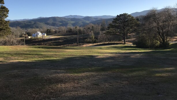 A rural landscape with a white house, open fields, and mountains in the background. - Tennessee's Finest Smoky Mountain Vacation Rental Getaway!  (Townsend)