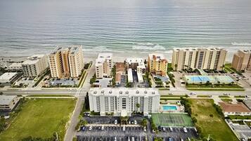 Un complexe hôtelier situé sur la côte, composé de plusieurs immeubles de grande hauteur, d’un parking et d’une piscine.