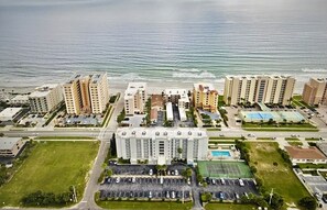 A coastal hotel complex with multiple high-rise buildings, a parking lot, and a swimming pool. - Sunny Days N Daytona @ Ocean Terrace Club. Family friendly. Ocean & River views (Daytona Beach Shores)