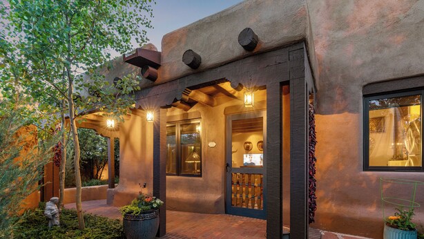 A rustic building with a stone facade, a covered entrance, and outdoor lighting.
