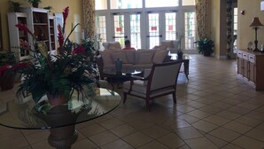 A spacious lobby with a high ceiling, large windows, and a variety of plants. - 25 minutes to Disney World! Family-sized townhouse (Kissimmee)
