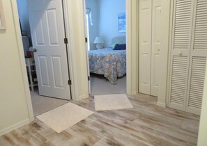 A bedroom with a bed, a nightstand, a lamp, and a closet. - Berm Bay un 22 Gorgeous Townhouse , White Sandy Beaches, elevator, heated pool (Bradenton Beach)