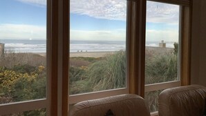 A room with three large windows offering a view of the beach and ocean. - Pacific Panorama - 5 bedrooms + loft (Bandon)