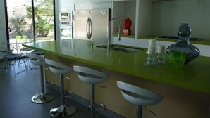 A modern kitchen with a large island, stainless steel appliances, and a view of the outdoors. - Indian Wells, CA - Luxury 3 Bedroom Vacation Home (Indian Wells)