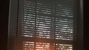 A window with horizontal blinds, a view of trees, and a sunset. - 15 PRIVATE ACRES !! WATERFRONT, SWIMMING POOL !! HOT TUB !!  PETS WELCOME TOO !! (RICHFIELD)
