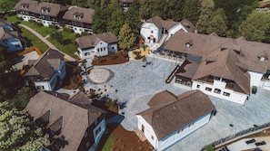 An aerial view of a residential area with multiple houses, a central courtyard, and surrounding greenery. - Hotel Breza (Podcetrtek)