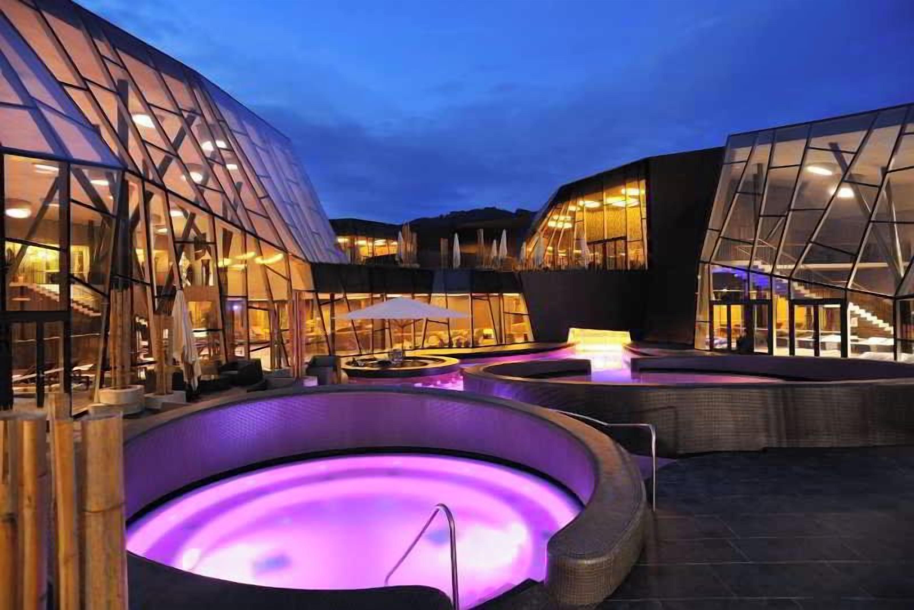 A modern building with glass facades and a heated outdoor pool area.