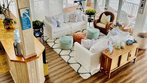 A spacious living area with a wooden floor, white sofas, and a view of the sea through large windows. - Beach Dream House, relax and enjoy the clear waters of Islamorada  FL  (Islamorada)