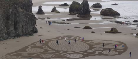A beach with large rocks and a sandy area with circular patterns.