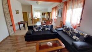 Uma sala de estar com sofá, mesa de centro e área de jantar com cadeiras e mesa.