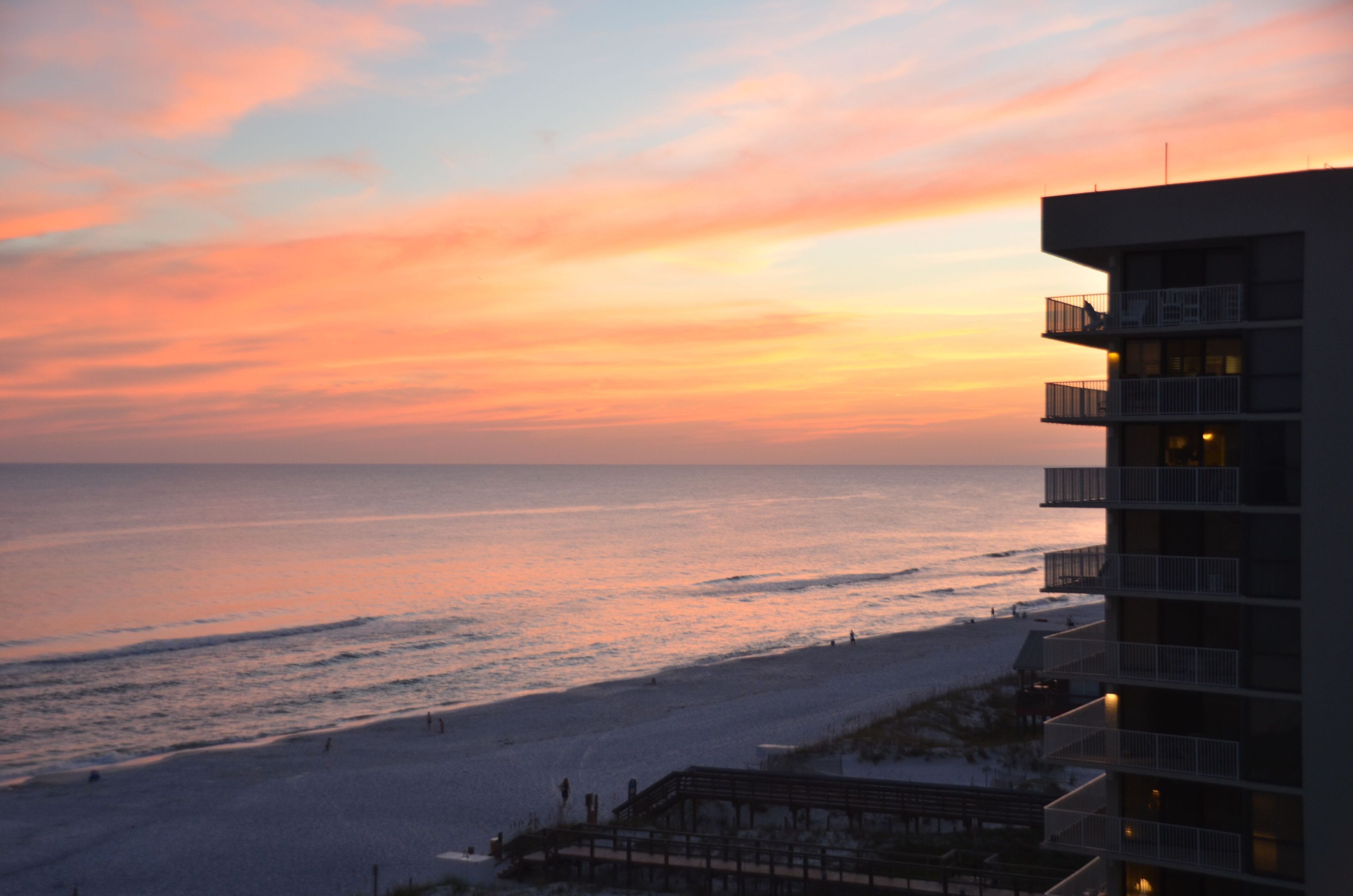 A beachfront hotel with multiple balconies overlooking the ocean.