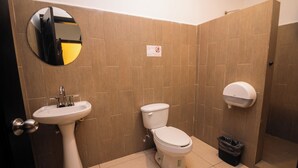 A bathroom with a sink, toilet, and hand dryer.