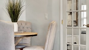A dining area with a tufted chair, a small round table, and a potted plant. - Beach House East of A1A, Private Hot Tub, Outdoor Oasis (Boynton Beach)