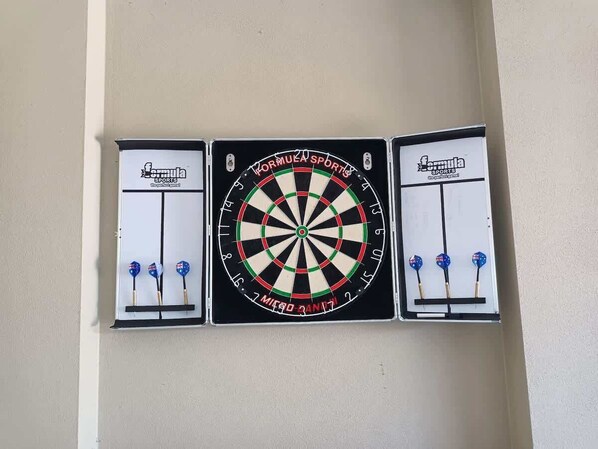 A dartboard mounted on a wall with three dartboards aligned horizontally.