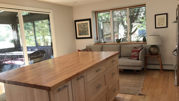 A modern kitchen with a wooden island, a built-in oven, and a large window overlooking a garden. - Peaceful Retreat in White Mountains (Sugar Hill)