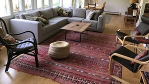 A modern living room with a sectional sofa, a coffee table, and a patterned rug. - Peaceful Retreat in White Mountains (Sugar Hill)