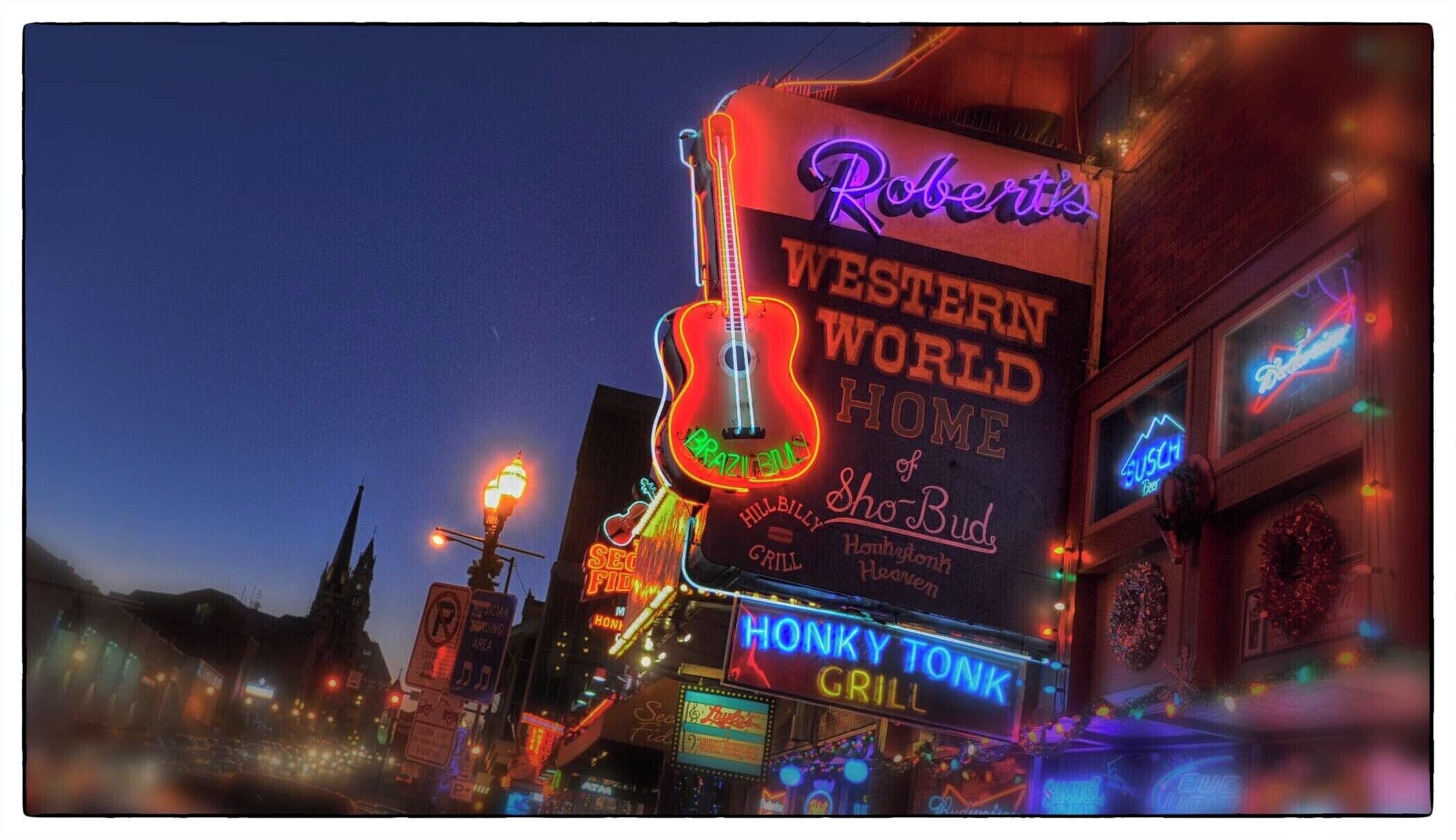 Un neon pubblicitario per Robert's Western World Home, con una chitarra e un'insegna per Honi's Grill.