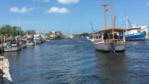 Un port de plaisance où sont amarrés plusieurs bateaux, dont un bateau orange et blanc bien visible, baptisé « St. Nicholas VIII ».