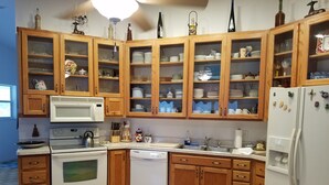 Une cuisine dotée de meubles en bois, d’un four à micro-ondes, d’une cuisinière, d’un lave-vaisselle et d’un réfrigérateur.