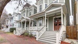 A two-story house with a front porch, a wooden gate, and a brick pathway. - Heated Pool Access | 5*Clean | Flex Cancelation (Savannah)