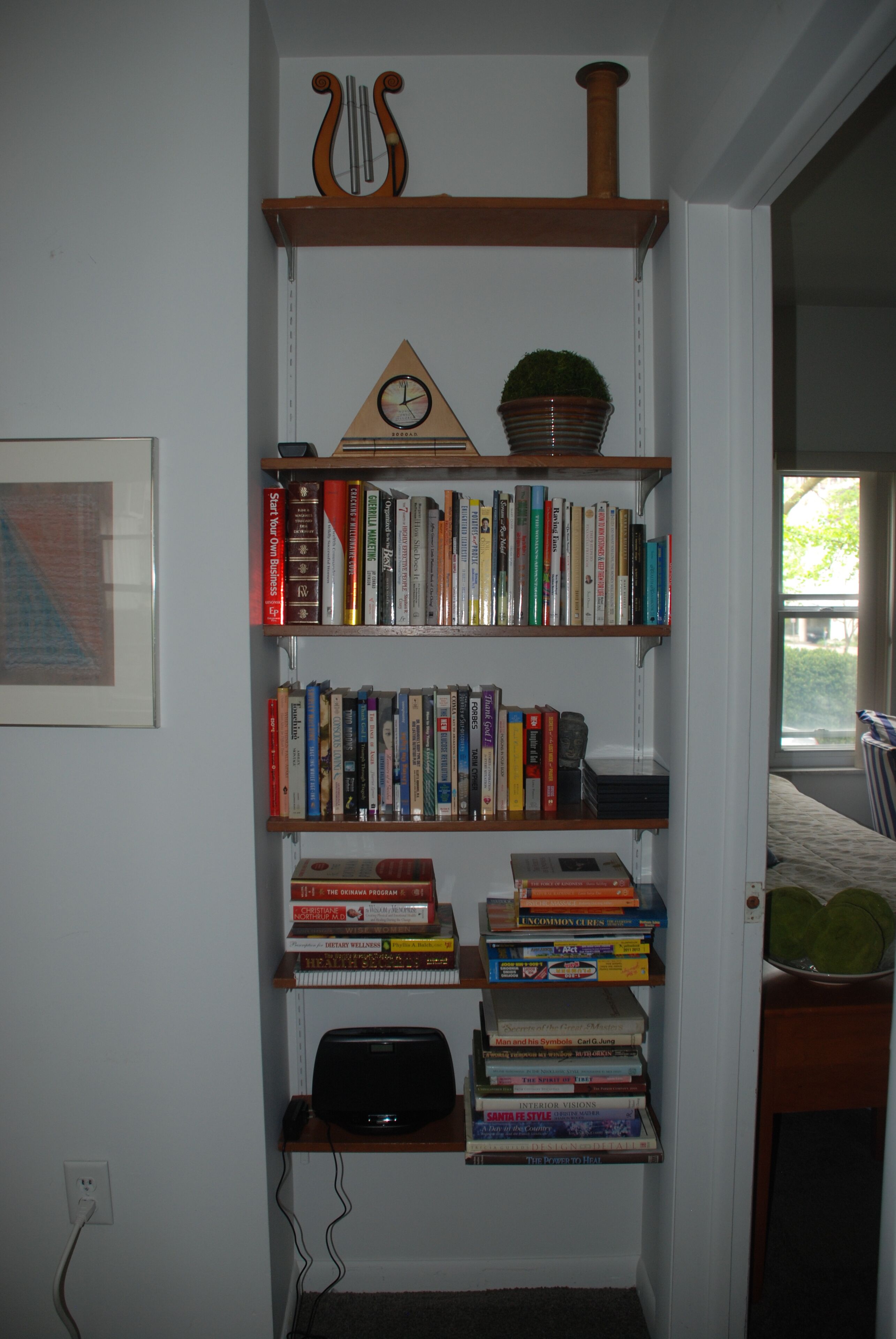 Ein Bücherregal mit verschiedenen Büchern und einer Uhr.