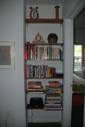 Een boekenplank met verschillende boeken en een klok.