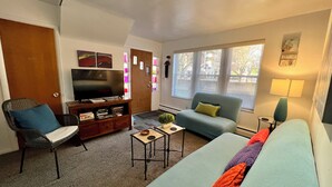 A living room with a sofa, a television, a coffee table, and a chair.