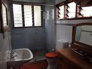 Ensuite bathroom with large shower and river pebbles underfoot.