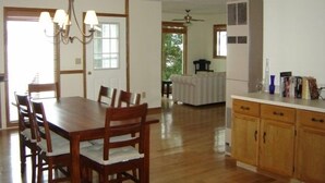 Una cocina amplia con armarios de madera, una mesa de comedor con sillas y un candelabro.