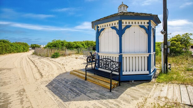 A small, single-story building with a blue and white exterior, located on a sandy beach with a wooden walkway leading to it. - Beachfront 3 BR condo in Diamond Beach with pool - Completely renovated for 2024 (Wildwood)