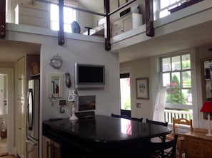 Una cocina con una isla grande, un refrigerador, un microondas y un comedor con sillas y una mesa.