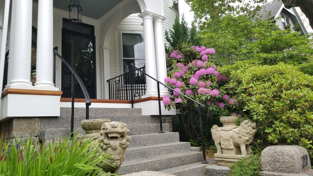 A house with a porch, stone steps, and a statue. - Charming Tree Top Victorian - Two Bedroom Retreat (Boston)